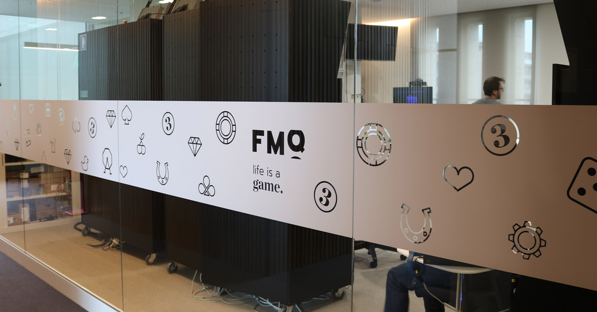 This image shows a regular glass from Fabamaq's office with the company logo and icons related to casino gaming.